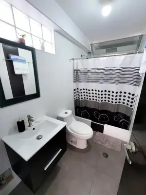 a bathroom with a black and white shower curtain and a toilet at Casa Bujama Playa y Piscina Privada in Bujama Baja