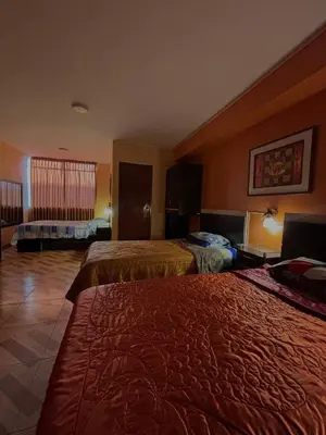 a hotel room with two beds and a window at Hospedaje Don Luciano in San Vicente de Cañete