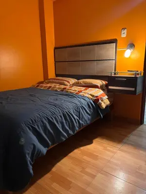 a bedroom with a large bed with a desk at Hospedaje Don Luciano in San Vicente de Cañete