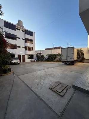 a truck parked in a parking lot next to a building at Hospedaje Don Luciano in San Vicente de Cañete