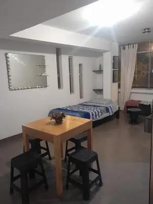 a room with a table and chairs and a bed at Minidepa San Bartolo in San Bartolo