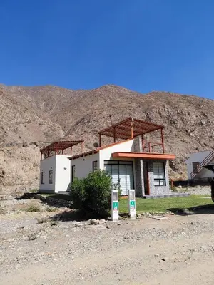 a house in the desert with a mountain in the background at Casa de Campo en Santa Rosa de Quivez in Santa Rosa de Quives