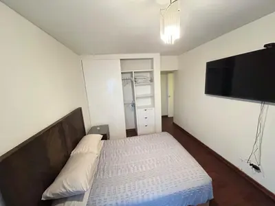 a bedroom with a bed and a flat screen tv at Miraflores kennedy view in Lima