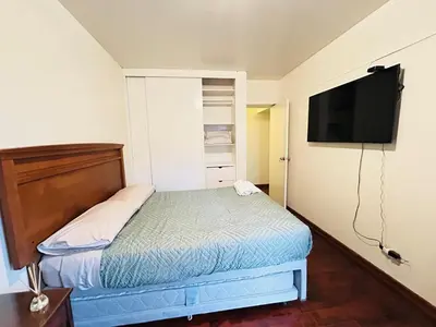 a small bedroom with a bed and a flat screen tv at Miraflores kennedy view in Lima