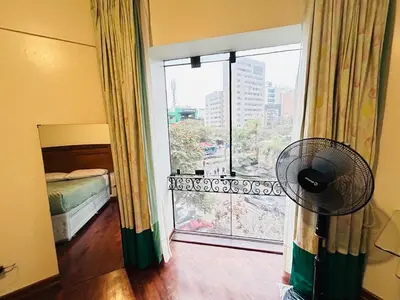 a room with a fan and a window with a view at Miraflores kennedy view in Lima