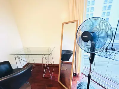 a fan in a room with a table and a mirror at Miraflores kennedy view in Lima