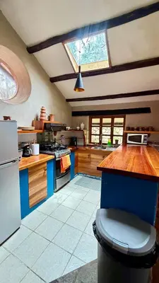 a kitchen with a blue island in the middle at Casa Munay in Urubamba