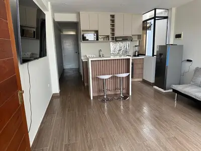 a kitchen with a counter and a bar with stools at Mn Depa en San Bartolo in San Bartolo