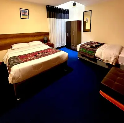 a bedroom with two beds and a blue carpet at Slaviero Home Cusco III in Cusco
