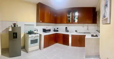 a kitchen with wooden cabinets and a refrigerator at Slaviero Home Cusco III in Cusco
