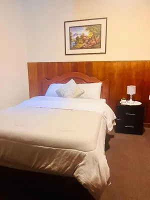 a bedroom with a large bed with a wooden headboard at Slaviero Home Cusco III in Cusco