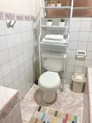 a bathroom with a toilet and a shelf with towels at Slaviero Home Cusco III in Cusco