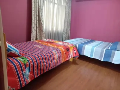 two beds in a room with purple walls and wooden floors at Casa Hospedaje Minidepa Piquichas in Abancay