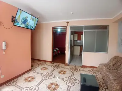 a living room with a couch and a tv on the wall at Casa Hospedaje Minidepa Piquichas in Abancay