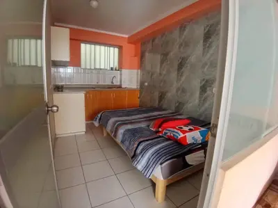 a room with a bed in a kitchen with orange walls at Casa Hospedaje Minidepa Piquichas in Abancay