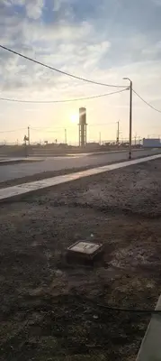an empty road with a water tower in the distance at Casa en condominio en Paracas, a 7 min del Chaco in Puerto Nuevo