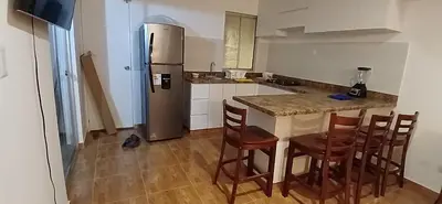 a kitchen with a refrigerator and a table and chairs at Casa en condominio en Paracas, a 7 min del Chaco in Puerto Nuevo