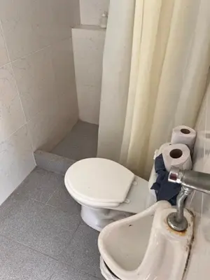 a white bathroom with a toilet and a sink at Departamento 201 in Punta Negra