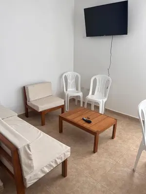 a living room with two chairs and a table and a tv at Departamento 201 in Punta Negra