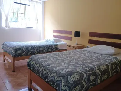 a bedroom with two beds and a window at Refugio del Caminante in Ollantaytambo