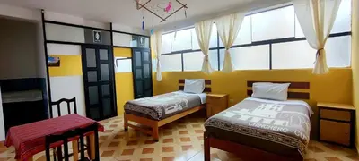 a room with two beds and a window at Refugio del Caminante in Ollantaytambo