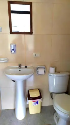 a bathroom with a sink and a toilet and a window at Lycka Wasi Hospedaje in Ollantaytambo