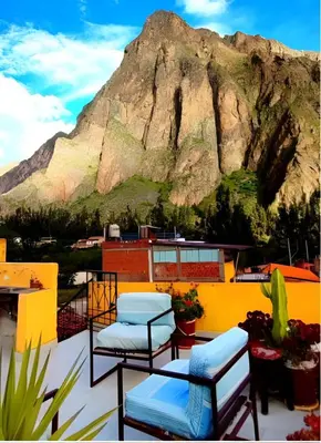 a balcony with chairs and a mountain in the background at Lycka Wasi Hospedaje in Ollantaytambo
