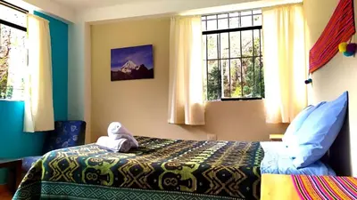 a bedroom with a bed with a stuffed animal on it at Lycka Wasi Hospedaje in Ollantaytambo