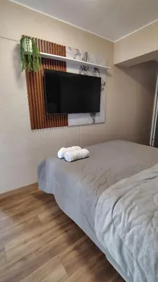 a bedroom with a bed and a flat screen tv at Vital Building - Modern Apartment Miraflores in Lima
