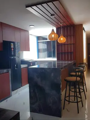 a kitchen with a black counter and some stools at Casa Quevedo in Ica