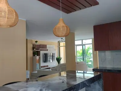 a kitchen with two pendant lights and a living room at Casa Quevedo in Ica