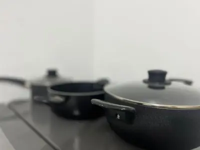 three pots and pans sitting on top of a counter at Habitación equipada en san juan de Lurigancho in Lima
