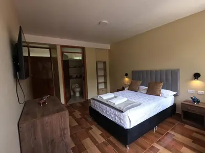 a bedroom with a bed and a flat screen tv at Apu Garden Lodge in Urubamba