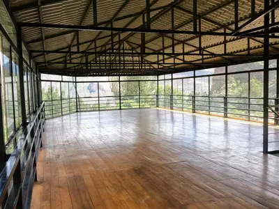 a large room with a wooden floor and windows at Apu Garden Lodge in Urubamba