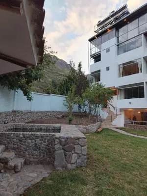 a stone wall in front of a building at Apu Garden Lodge in Urubamba
