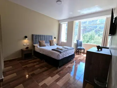 a bedroom with a bed and a large window at Apu Garden Lodge in Urubamba
