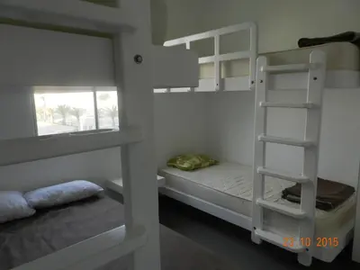 two bunk beds in a room with a bed at Departamento con Vista al Mar - Paracas - Condominio Nautico Las Velas in Paracas