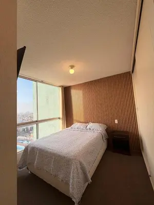 a bedroom with a bed and a large window at Costanera Uno Vista al Mar in Lima