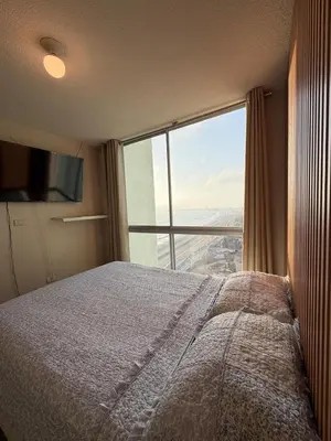 a bedroom with a bed and a large window at Costanera Uno Vista al Mar in Lima