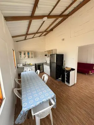 a kitchen with a table and chairs in a room at Amplia casa petfriendly con parrilla cerca a Asia in Salitre