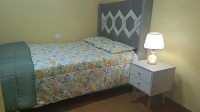 a bedroom with a bed and a nightstand with a lamp at Boulevard home hostel - Lima Airport in Lima