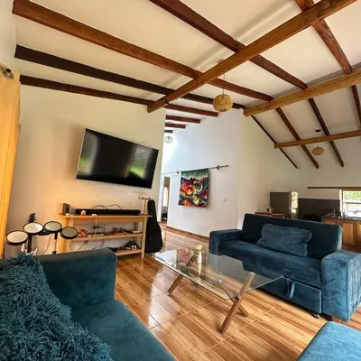 a living room with two blue couches and a flat screen tv at Cancha Wasi A modern, cozy and fully equipped house in Urubamba