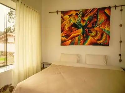 a bedroom with a bed and a painting on the wall at Mountain retreat with private sauna in Urubamba in Urubamba