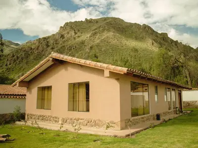 a house with a mountain in the background at Mountain retreat with private sauna in Urubamba in Urubamba