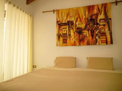 a bedroom with a bed and a painting on the wall at Mountain retreat with private sauna in Urubamba in Urubamba