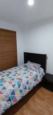 a bedroom with a bed with a colorful quilt at Condominio Vive Paracas in Puerto Nuevo