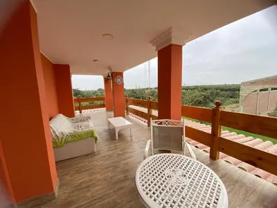 a room with a balcony with a table and a view at La Casona - Hospedaje Campestre in El Carmen