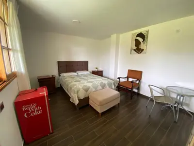 a bedroom with a bed and a table and chairs at La Casona - Hospedaje Campestre in El Carmen