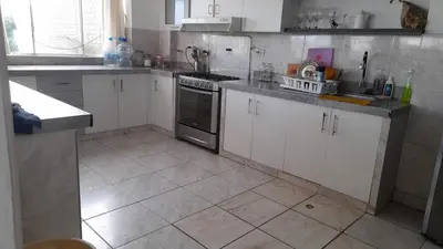 a kitchen with white cabinets and a tile floor at Casa Frente al mar en club privado in Lurín