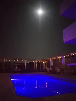 a swimming pool at night with a full moon at Finca Lucía Kemper in San Vicente de Cañete